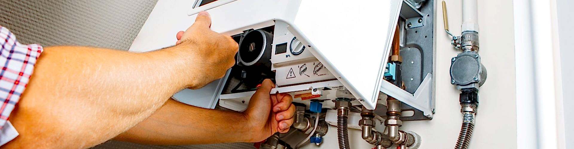 Plumber attaches Trying To Fix the Problem with the Residential Heating Equipment. Repair of a gas boiler